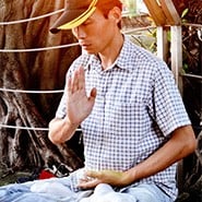 A man sitting outside, meditating.
