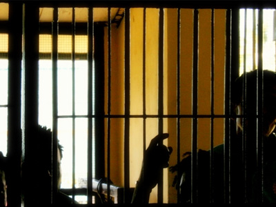 Silhouette of men behind prison bars.