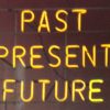 The words past, present, and future in yellow neon.