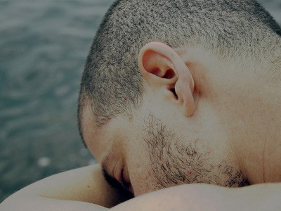 رجل برأس يستريح على أذرع مطوية.
