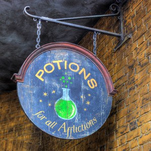 A blue sign with a green color potion in a bottle and the words: Potions for all Afflictions