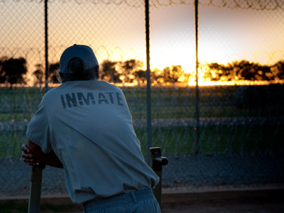 A photo showing an inmate back, looking at the sunset.