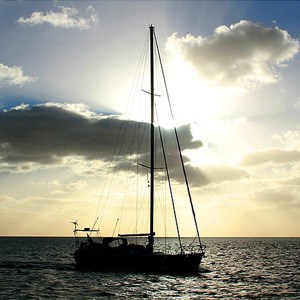 Silhouette of a sailboat in front of a sunset.