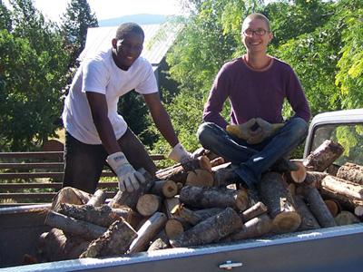 Ulric and friend Exiquio in the bed of a truck, loading firewood.