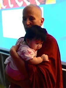 Venerable Chodron holding a baby.