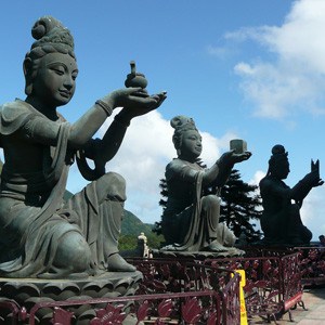 3 statue of women raising up their hands offering food