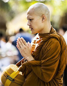 Tajski mnich ze złożonymi dłońmi.