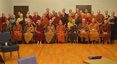 Large group of monastics from various traditions sitting together.