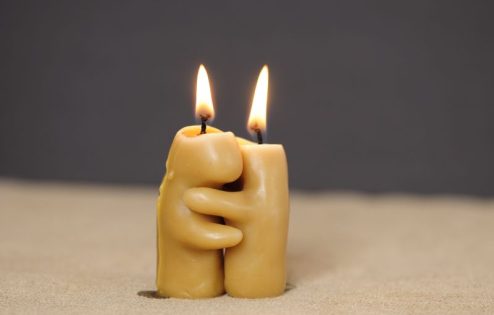 Two candles hugging as they burn down
