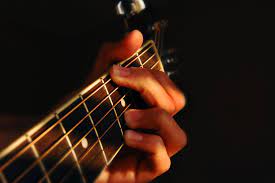Closeup of hands of someone playing guitar.