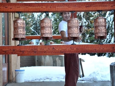 An Abbey guest turning prayer wheels at Chenrezig Hall.