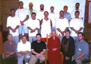 Venerable Chodron standing with a group of inmates.