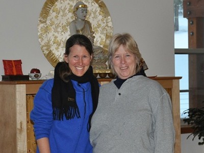 Heather with fellow retreatant, Cindy, in front of the Chenrezig Hall altar.