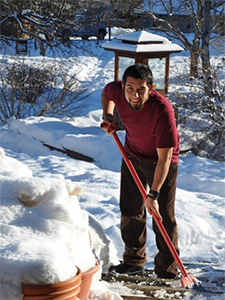 Winter retreatant, Isaac, cleaning snow from a walkway.