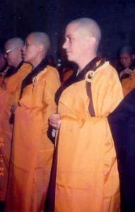 Venerable Chodron standing in formal robe with other nuns.
