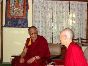 Venerable Chodron and His Holiness the Dalai Lama sitting together, talking.
