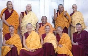 Czcigodny Chodron stojący z grupą mnichów.