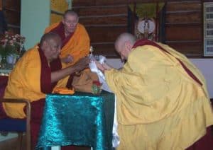 Czcigodny Chodron ofiarowuje mandalę Khensurowi Rinpocze.
