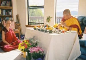 Venerable Chodron sitting as Khensur Rinpoche blesses the statues and thangkas.