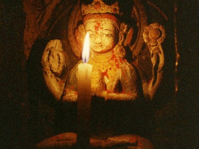Candle offering to small statue of Chenrezig.