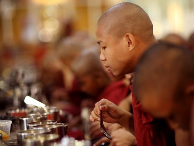 A monk looking into his bowl of soup.
