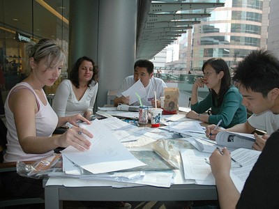 A group of young coworkers sitting around a table, working.