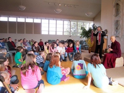 Venerable Chodron shares the story of the prayer wheel with the children at UU.