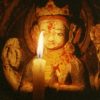 Candle offering to small statue of Chenrezig.