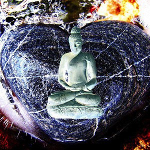 Statue of a Buddha in front of a heart-shaped stone.