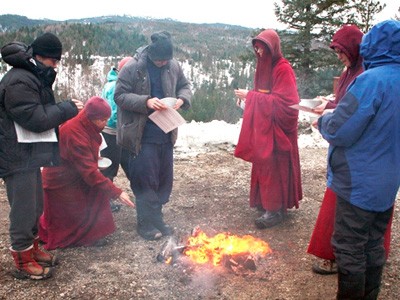 Abbey monastics and guests throwing sesame seeds into fire.