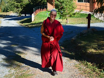 Venerable Jampa walking outside and smiling.