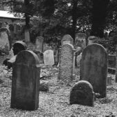 Black and white image of tombstones in a cemetery.