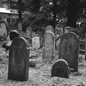 Black and white image of tombstones in a cemetery.