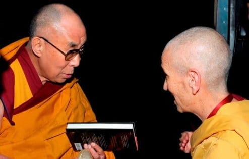 Venerable Thubten Chodron offers the book to His Holiness backstage at the Beacon Theatre in New York.