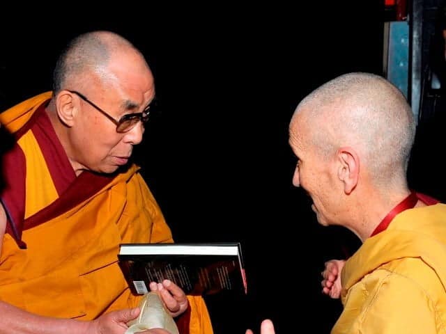 Venerable Thubten Chodron offers the book to His Holiness backstage at the Beacon Theatre in New York.