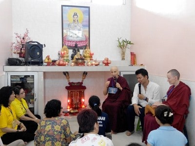 Venerable Chodron and Venerable Samten sitting with a group of inmates in the Medan prison chapel.