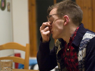 Man looking agitated, holding his head in his hand.