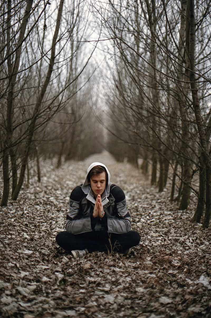 young man in forest meditating