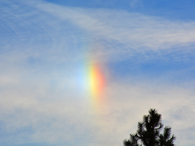 A rainbow-colored sun halo against blue sky.
