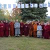 Group of monastics standing under prayer flags.