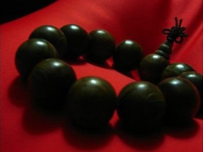 Brown mala on red cloth.