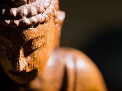 Wooden buddha statue on table.