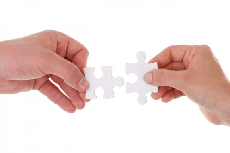 Two people putting puzzle pieces together
