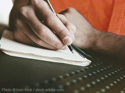 Man writing in a notebook.