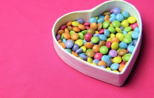 Multi-colored candy in heart-shaped bowl