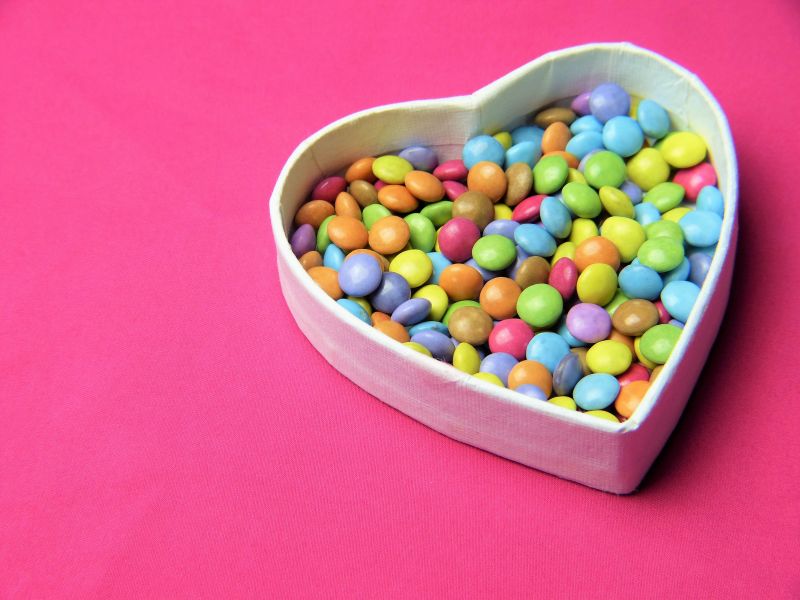Multi-colored candy in heart-shaped bowl