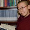 Venerable Damcho smiling and holding one of the texts.