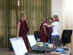 Two Tibetan nuns and two laypeople talking to each other.