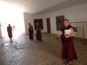 Grupa tybetańskich zakonnic, jedna uśmiechnięta.