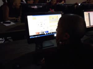 एक तिब्बती नन कंप्यूटर स्क्रीन को देख रही है।
